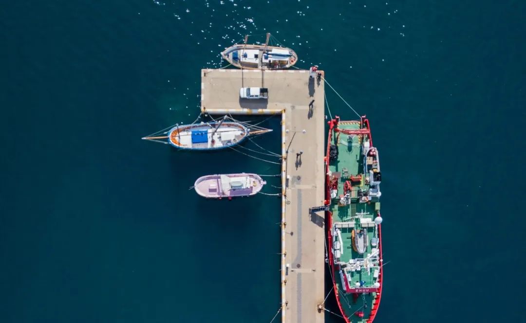 aerial photography of white and red boats near gray dock at daytime